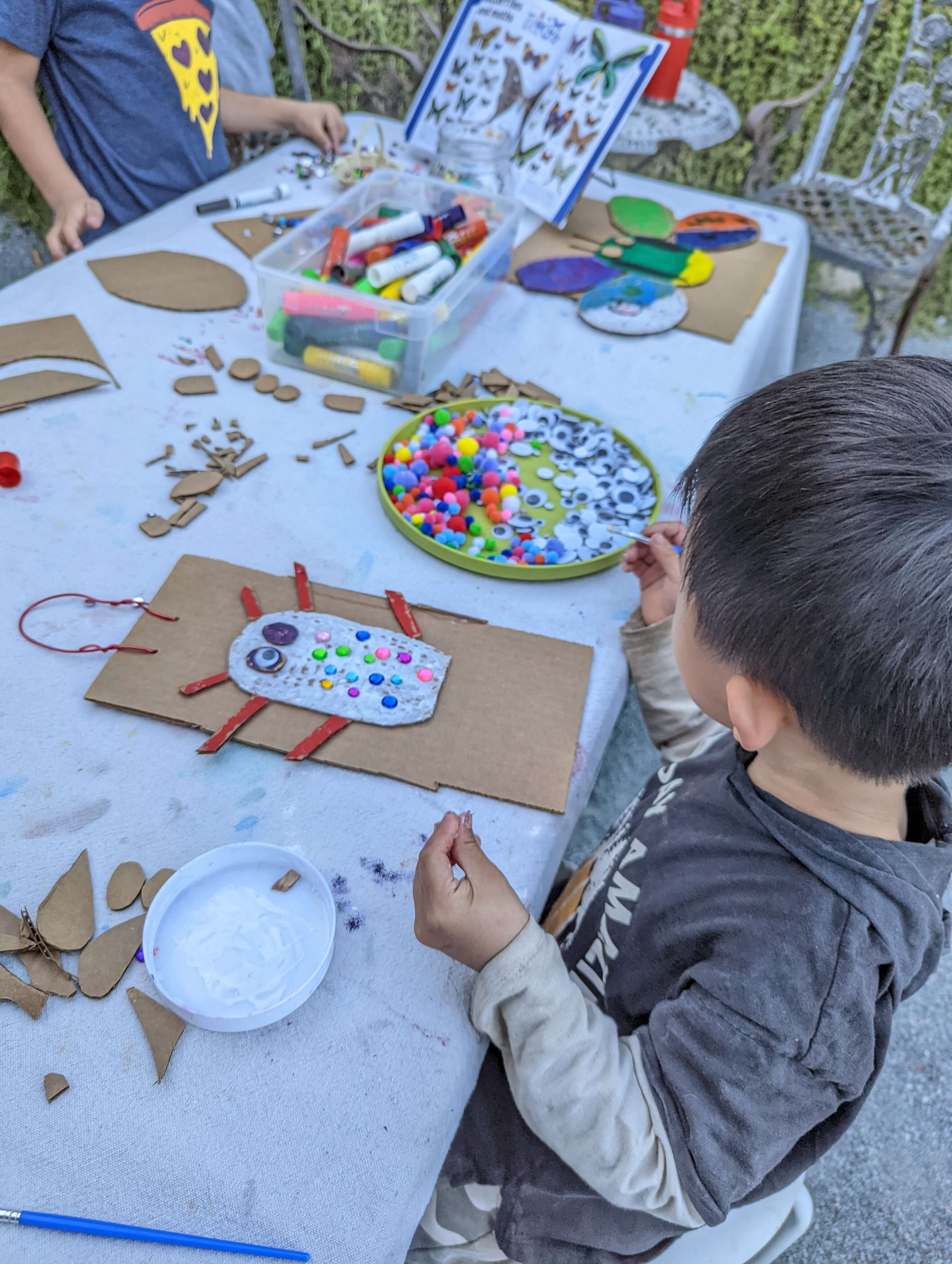 Young kids painting independently at Pachis art studio outdoor class, Linda Vista San Diego